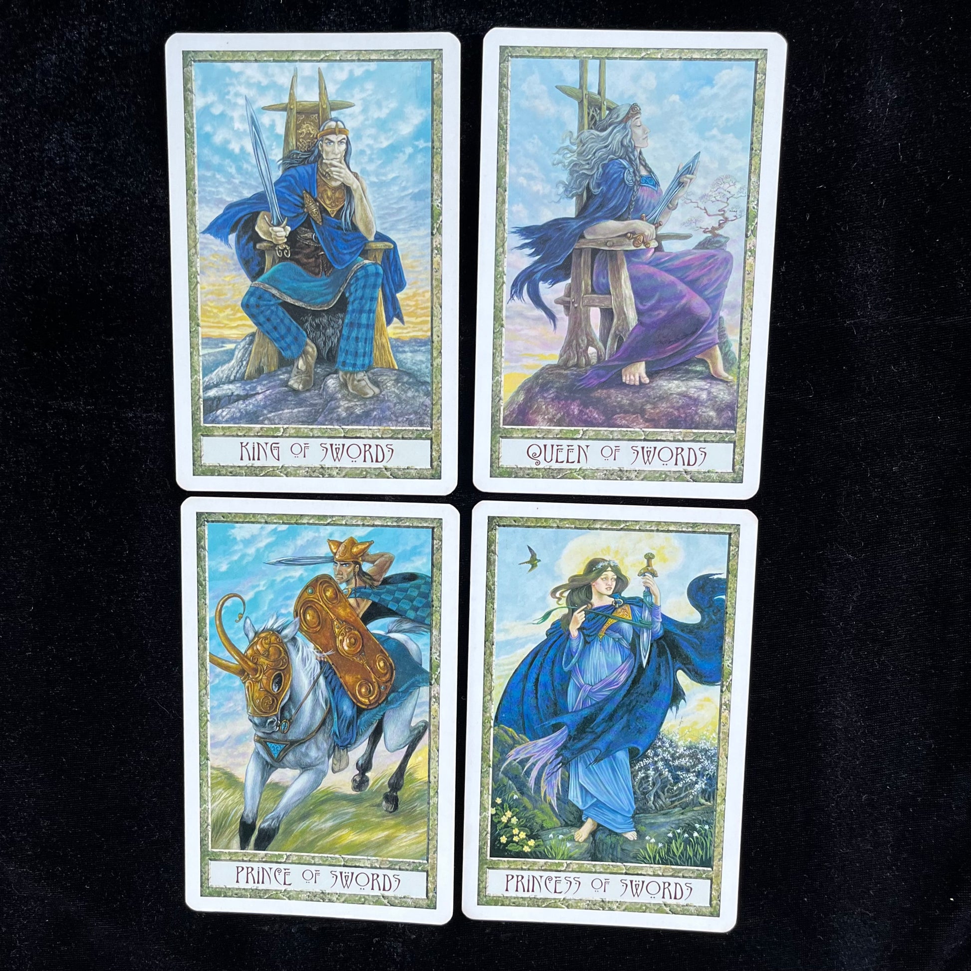 Four tarot cards featuring King, Queen, Prince, and Princess of Swords on a black background.