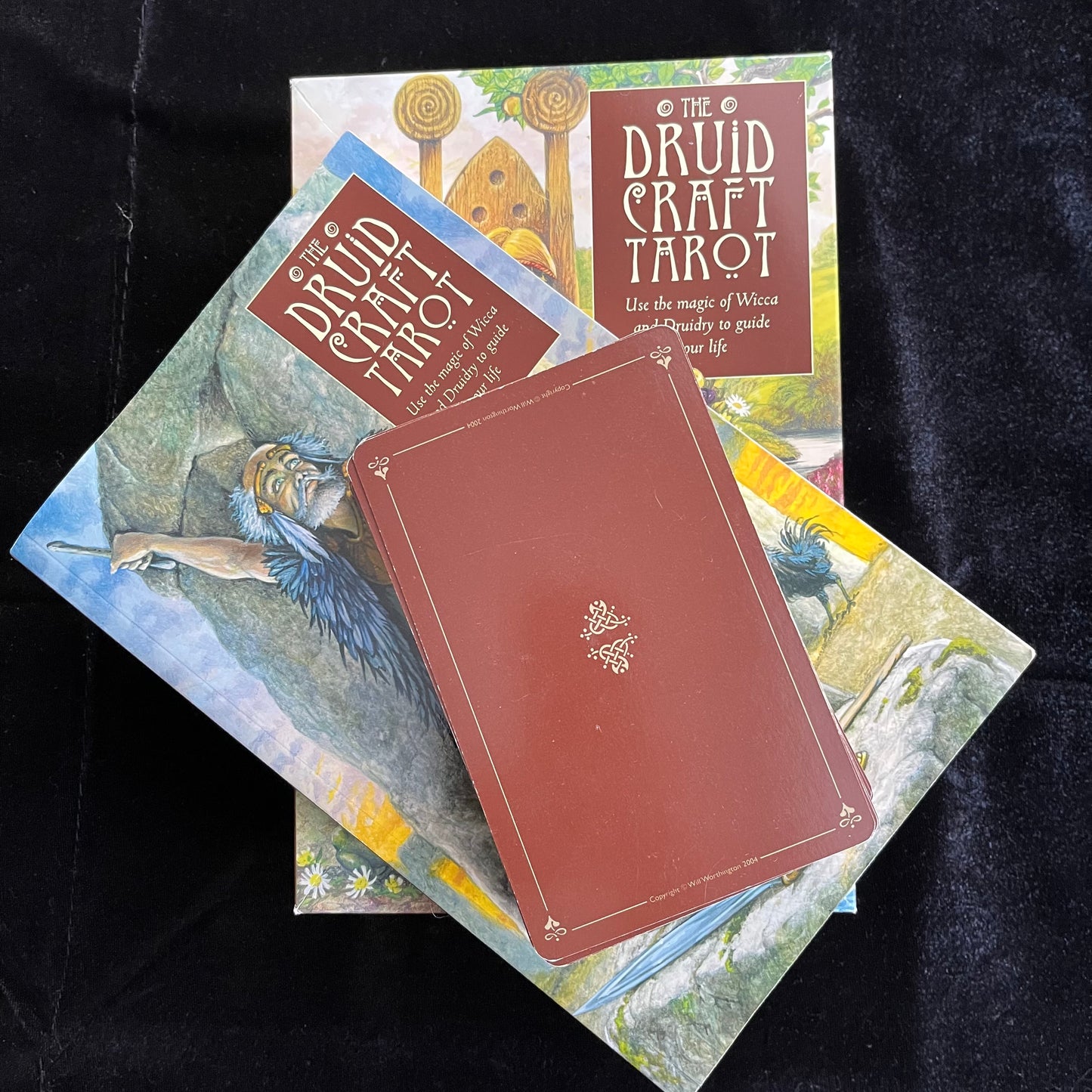 Druid Craft Tarot cards and book on a dark background