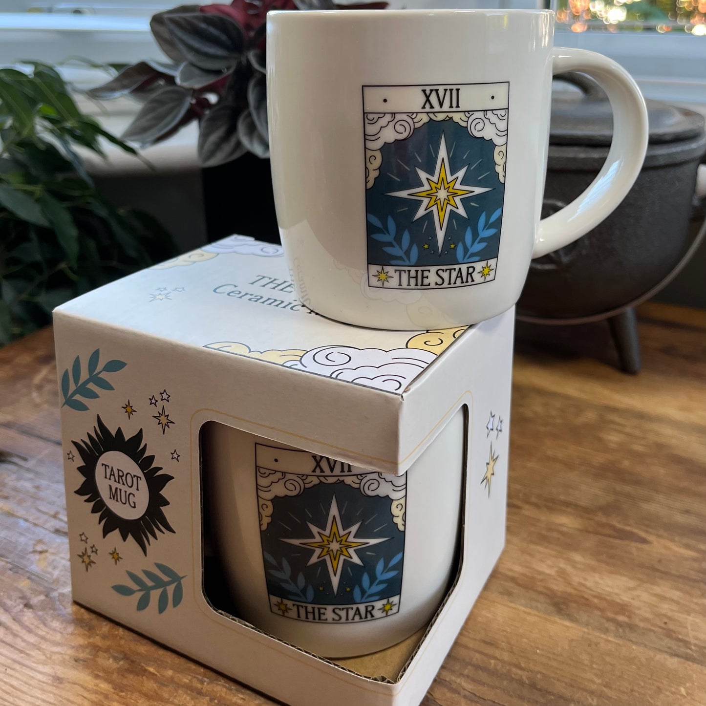 White mug with 'The Star' tarot design in a box on a wooden surface