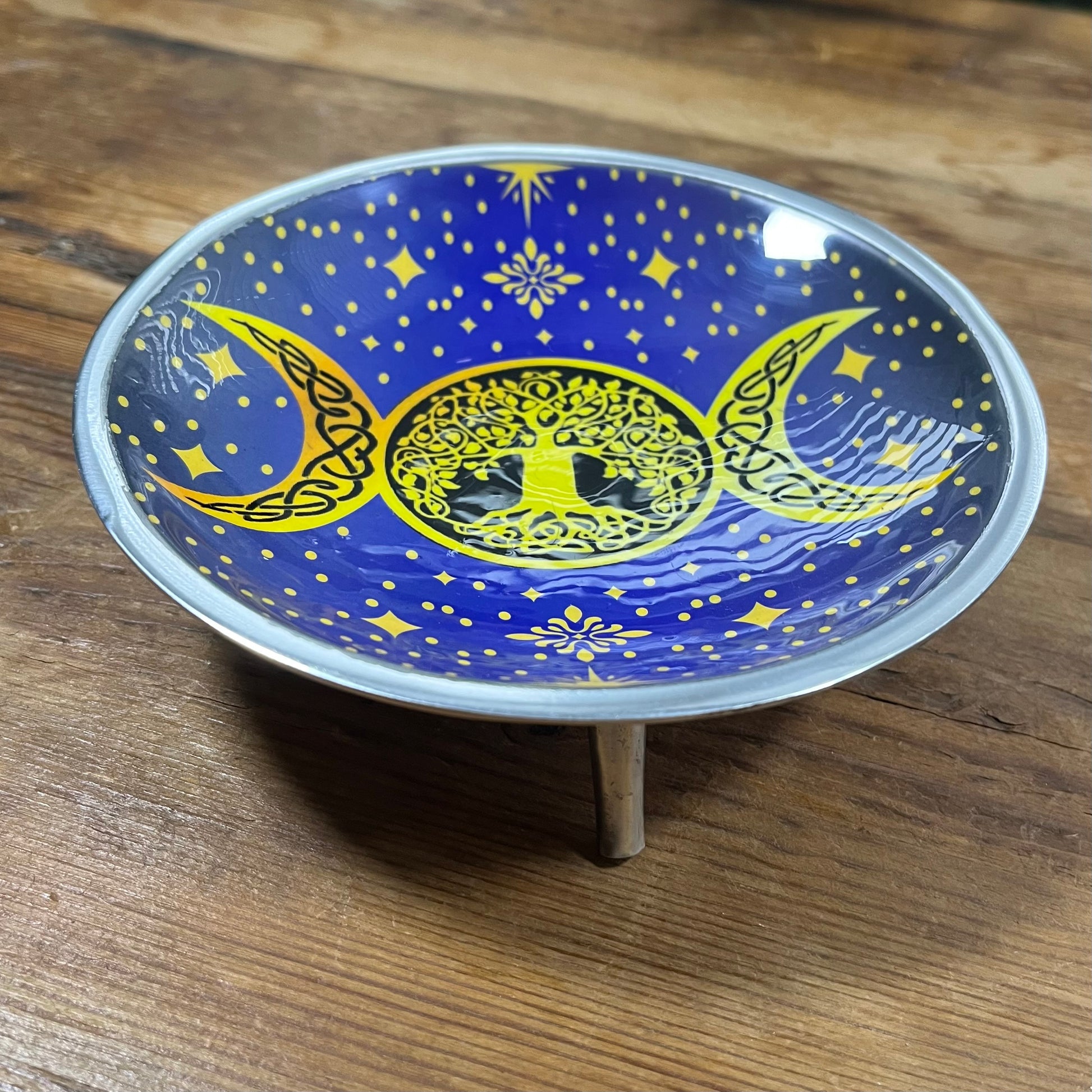 Decorative plate with celestial design on a wooden surface