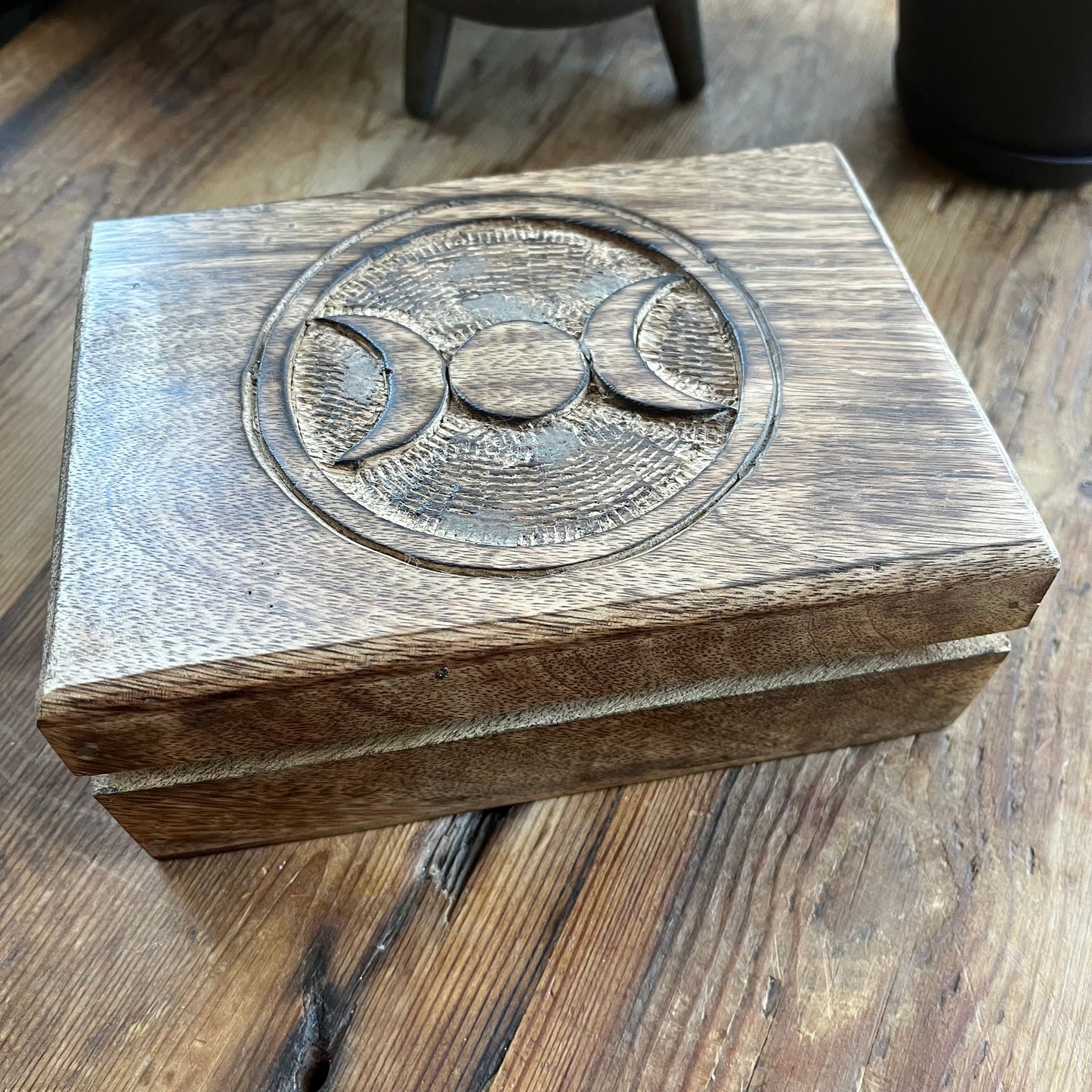 Wooden box with engraved Triple moon symbol on a wooden surface