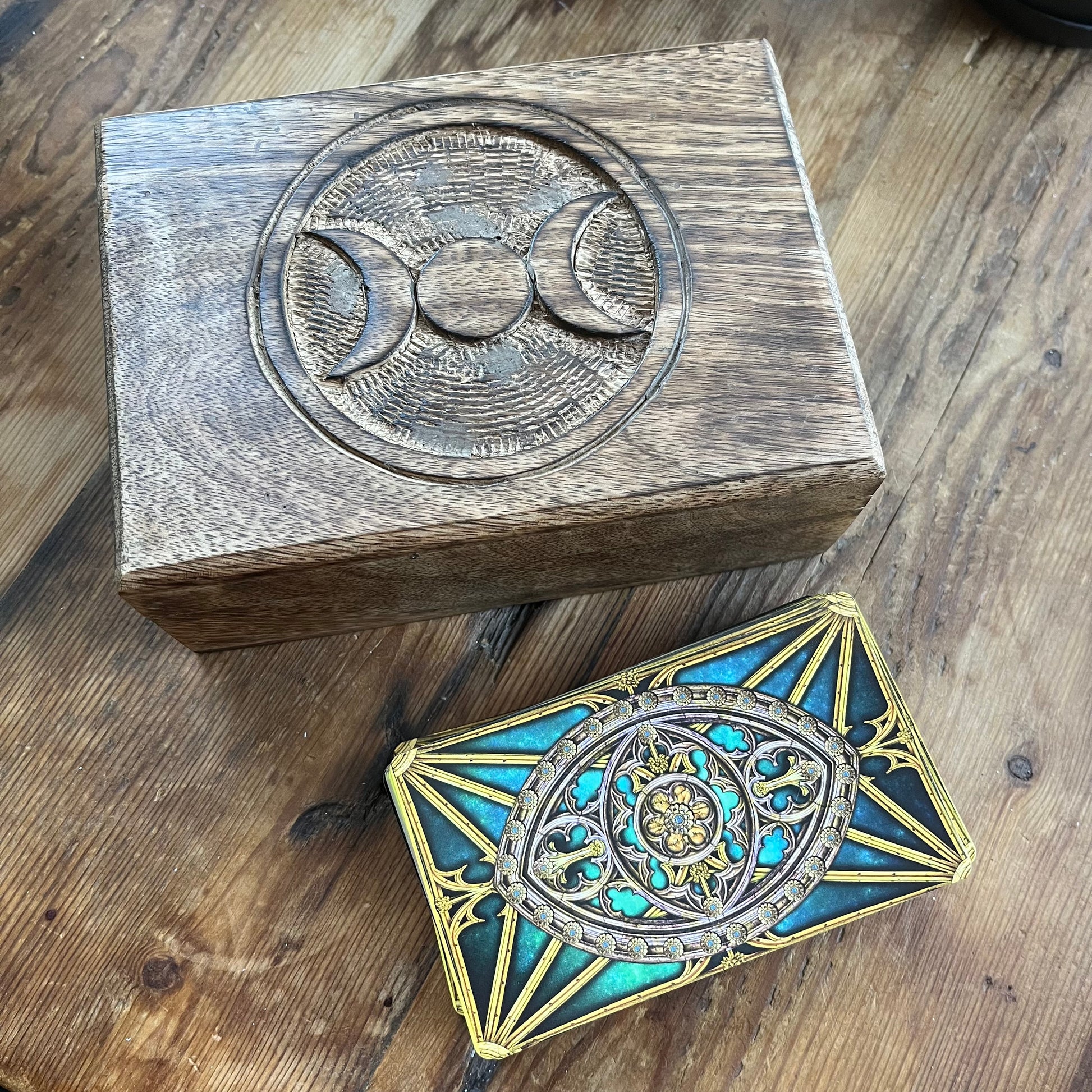 Wooden box with moon symbol and decorative Tarot Cards on wooden surface
