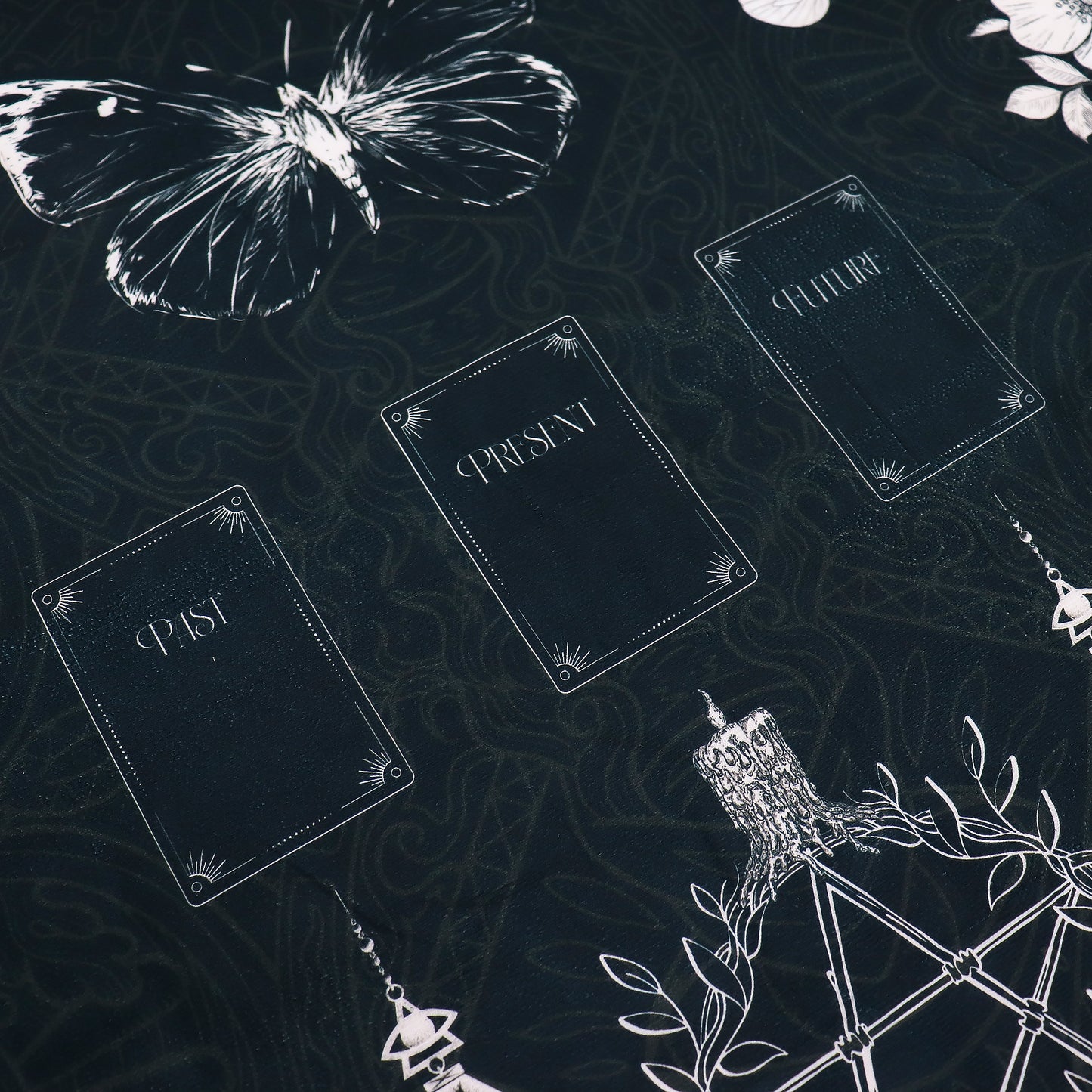 Decorative Tarot reading cloth with text 'PAST', 'PRESENT', 'FUTURE' and white butterfly on a dark background.