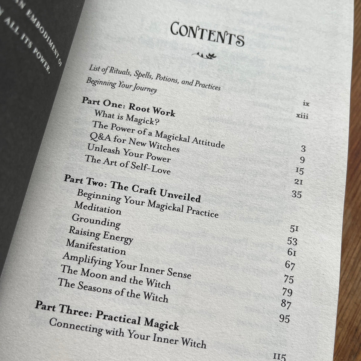 A close-up of a printed book or booklet page showing the contents list with headings like 'Part One: Root Work' and 'Part Two: The Craft Unveiled' on off-white paper.