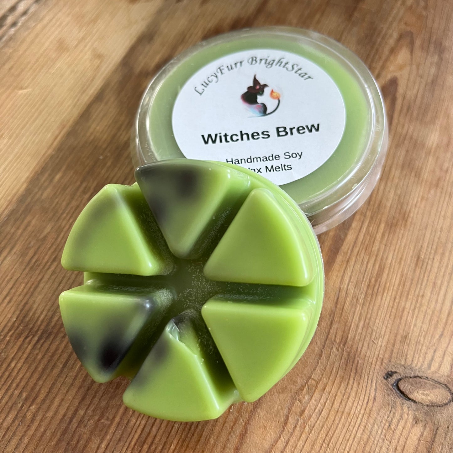 Green wax melts in a mold with a container labeled 'Witches Brew' on a wooden surface.