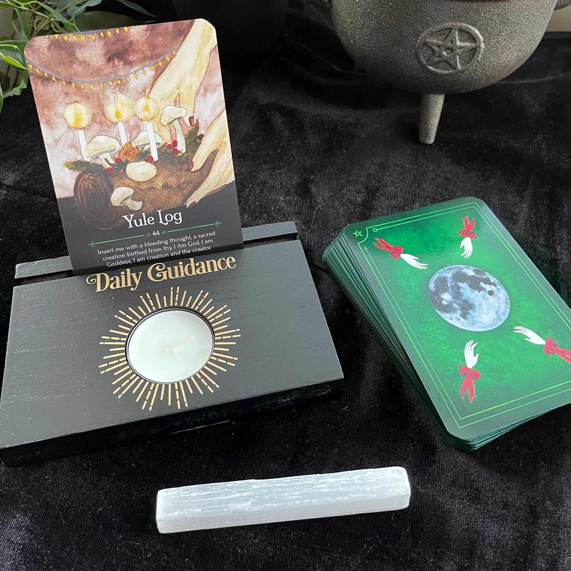 Witchcraft-themed items including tarot cards and a Yule Log on a dark surface.