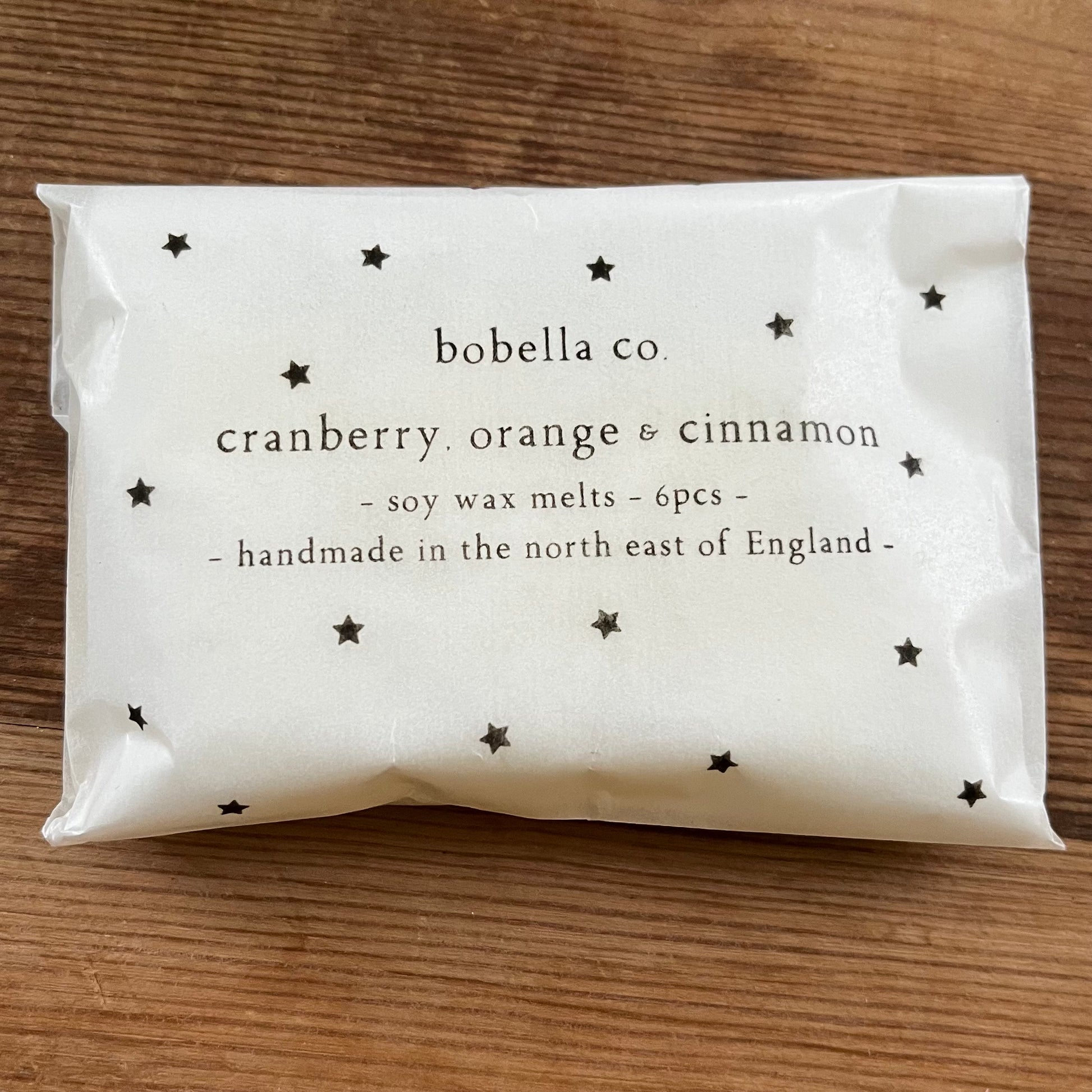 Packaged Christmas scented soy wax melts with 'bobella co' branding on a wooden surface