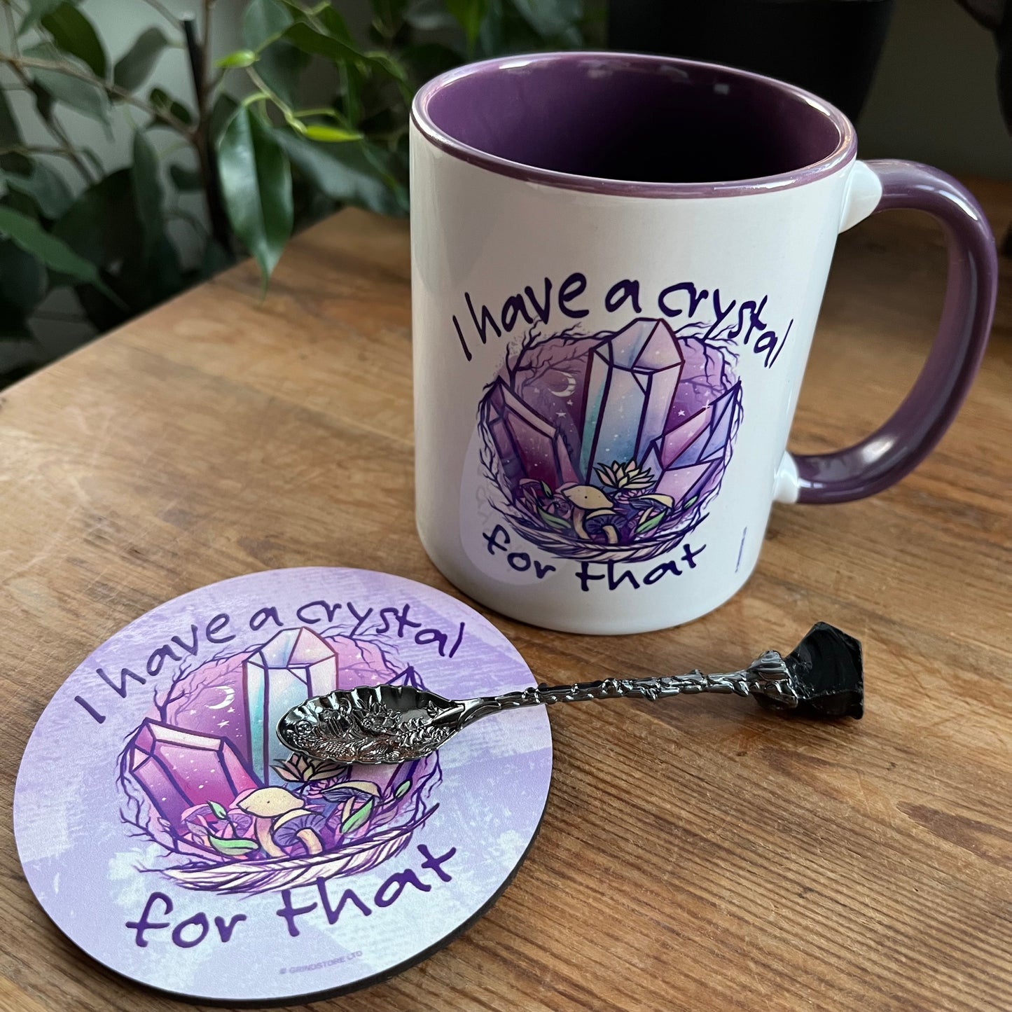 Mug and coaster with crystal design and text on a wooden surface