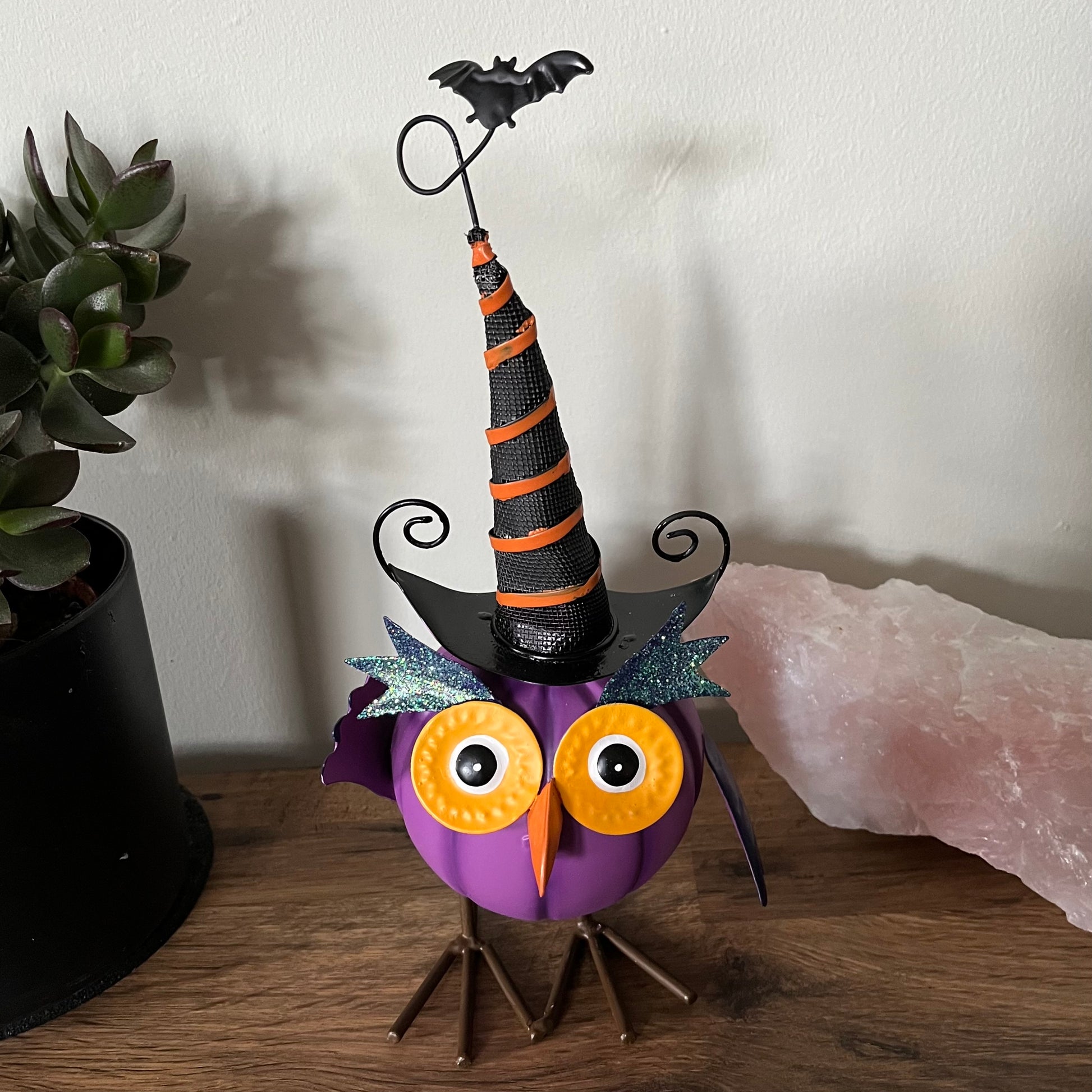 Halloween-themed owl figurine with a witch hat on a wooden surface.