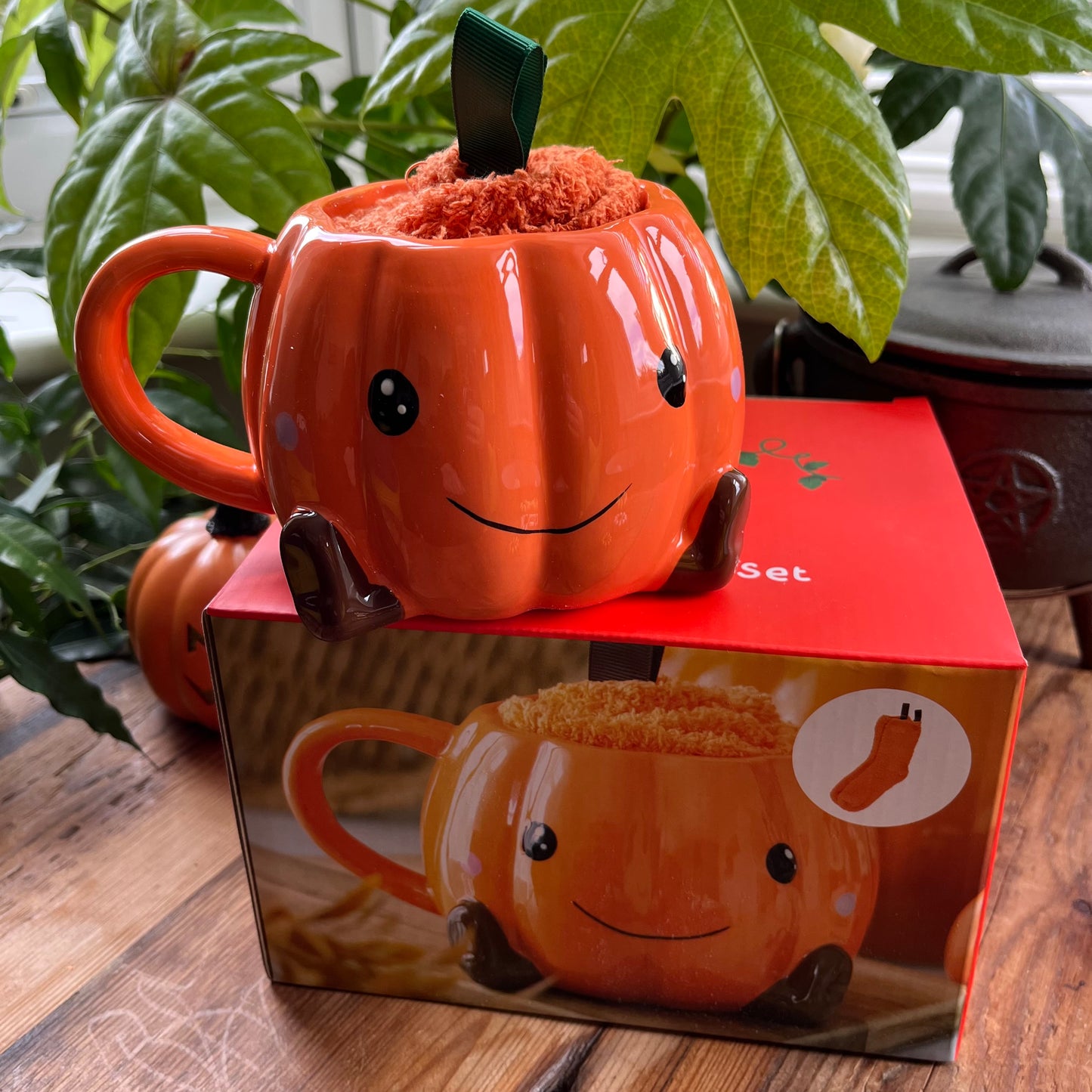 Pumpkin-shaped mug with a smiley face on top of a matching mug set box.