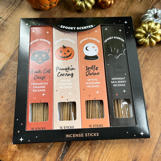 Spooky scented incense sticks set in a black box on a wooden surface with Halloween decorations.