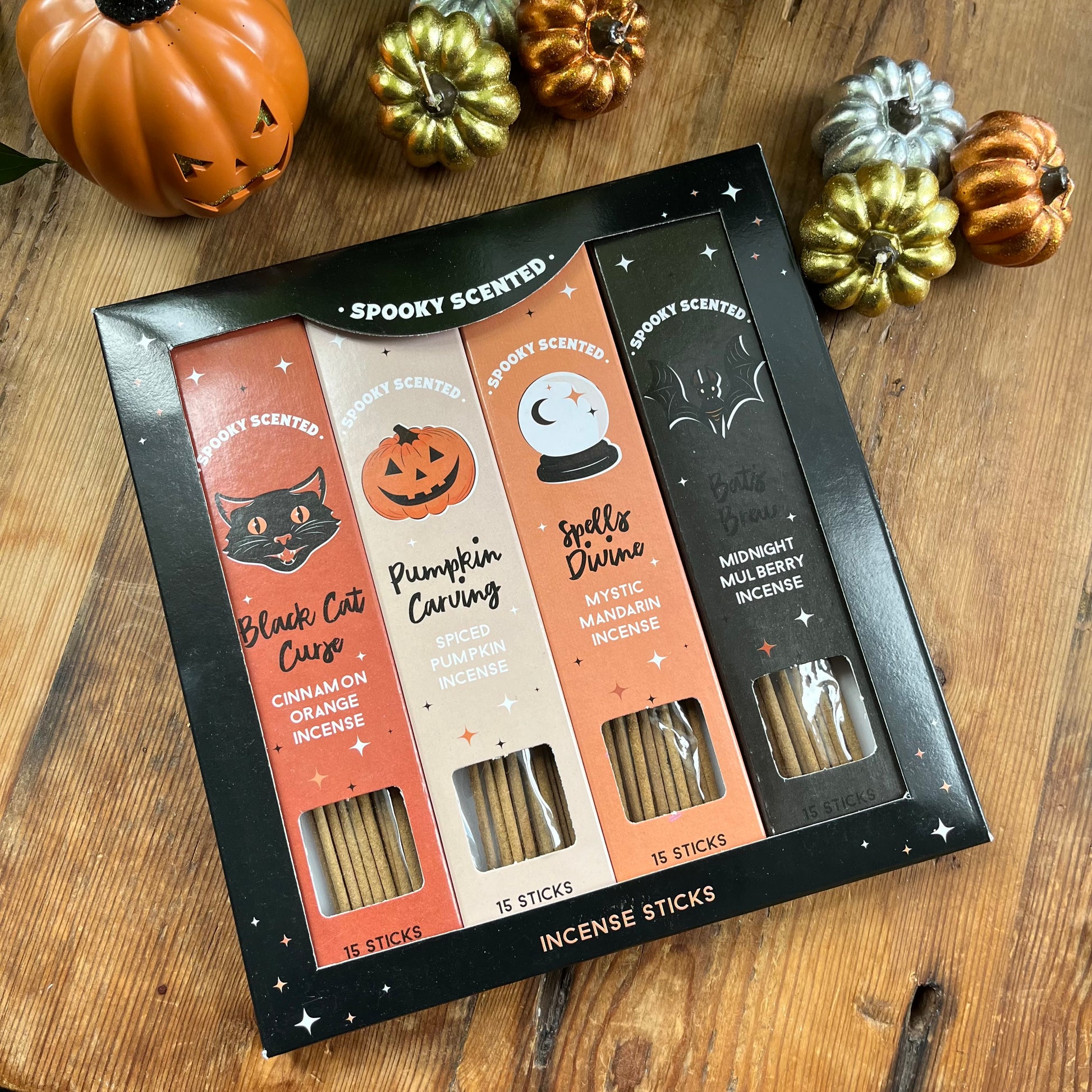 Spooky scented incense sticks set on a wooden surface with decorative pumpkins.